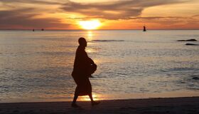 Buddhist Monk walking under the sunset in the South of Thailand